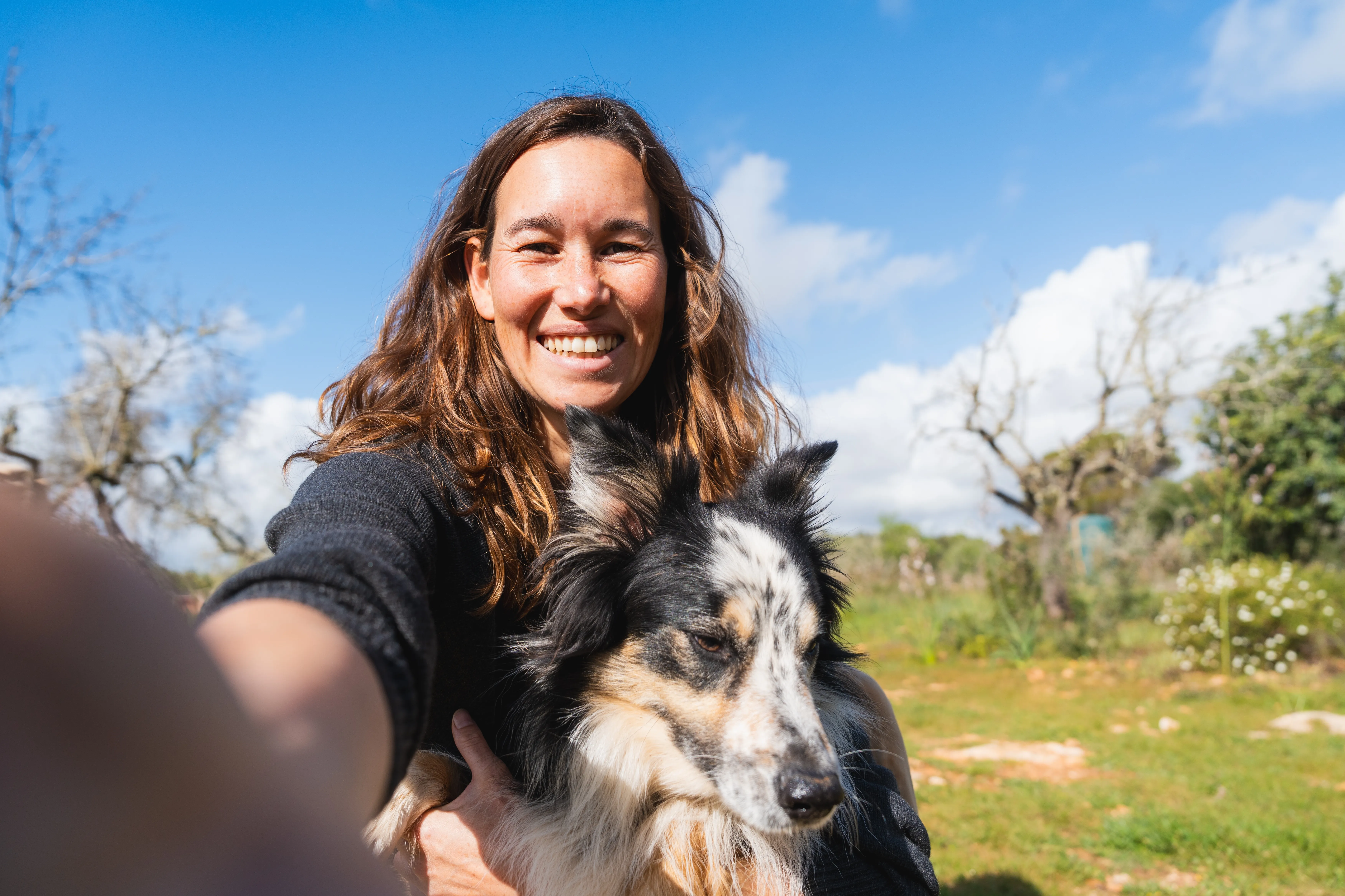 Woman sitting on a sofa with a dog resting beside her