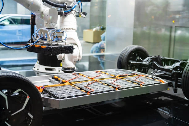 Technician inspecting advanced electric vehicle battery architecture modules on a clean assembly workspace table