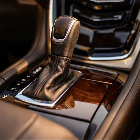 Interior center console featuring a leather gear shifter knob inside a luxury SUV cabin