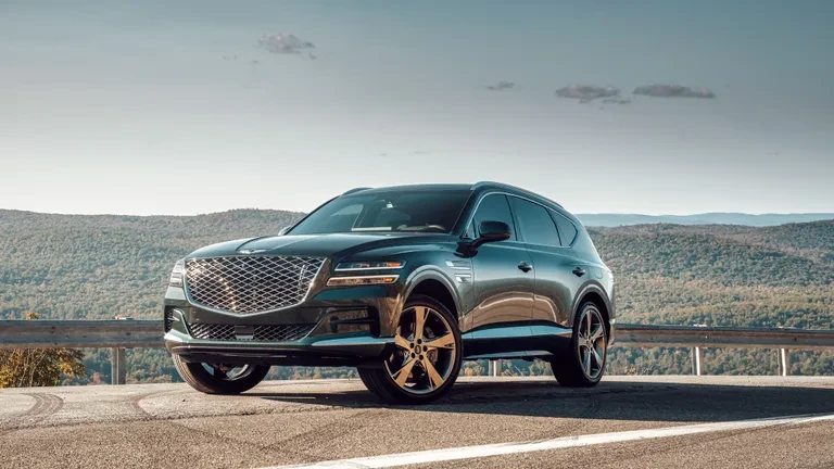 Modern luxury SUV parked against an urban architectural backdrop during golden hour light