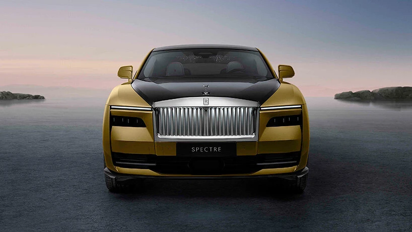 Luxurious electric Rolls-Royce Spectre coupe parked in a modern architectural driveway at twilight with glowing illumination