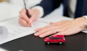 Warranty documentation and service contract papers organized on desk showing coverage terms and verification requirements for exotic vehicle purchase