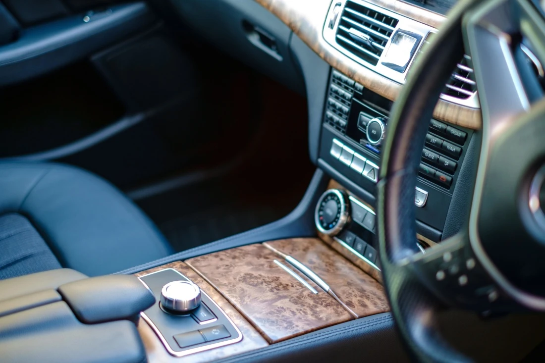 Modern luxury car dashboard featuring high resolution digital displays leather wrapped steering wheel and ambient lighting