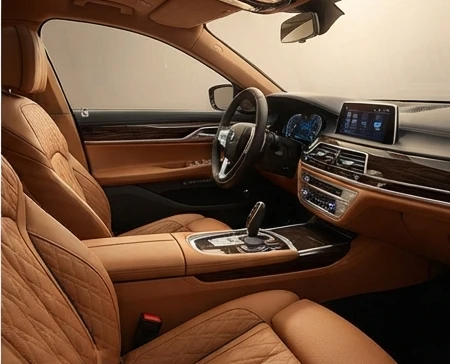 Opulent luxury car interior featuring fine leather seats, polished wood trim, and a modern digital dashboard